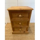 A pine three drawer bedside table (H65cm W45cm D38cm)