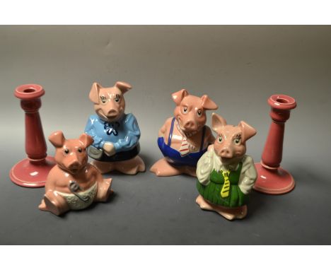 A set of four NatWest piggy money banks; a pair of Ault candlesticks, glazed throughout in pink, impressed marks (6)