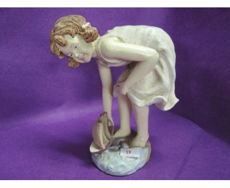 A vintage plaster cast figure of a child at play on the beach 