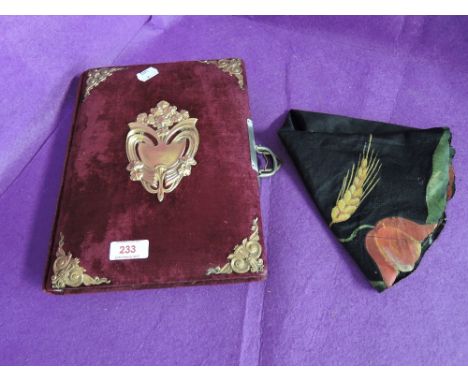 A vintage photo album with red velvet cover