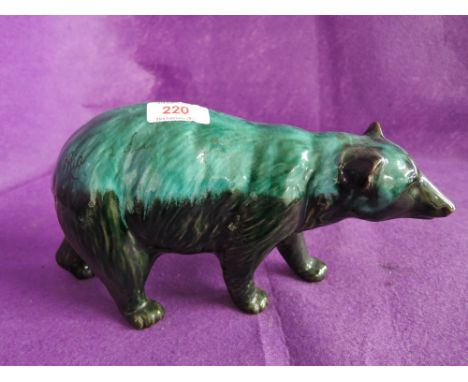 A vintage ceramic bear figurine in green and black glaze