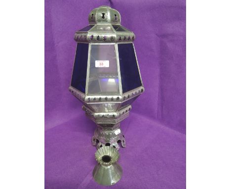 A large bohemian style light fitting with clear and blue glass in metal frame