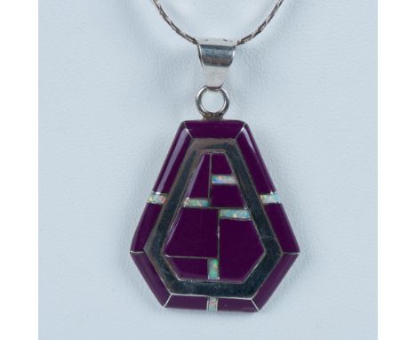 Beautiful Southwest Native American pendant by Navajo jewelry artist, Cecil Sanders. It is made of sterling silver inlaid wit