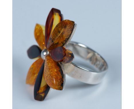 This pretty large ring is made from sterling silver and natural amber. The band is stamped ER and 925. It is a size 8.25, but