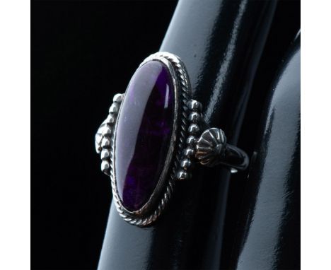 Beautiful Southwest Native American ring that features an oval sugilite stone set in hand crafted sterling silver with a geom