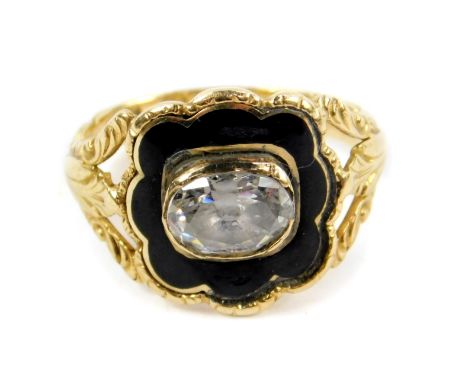 A George IV 18ct gold paste and enamel mourning ring, set with an oval cut paste, on an open shank with foliate engraved shou