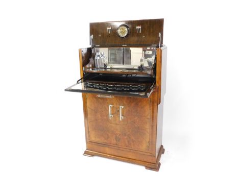 An Art Deco walnut and burr walnut cocktail cabinet, the rise and fall front opening to reveal a mirror backed fitted interio