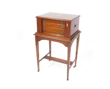 A George V silver rat tail part canteen of cutlery, in a three drawer mahogany cabinet on stand, with brass shield escutcheon