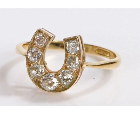 18 carat gold diamond set ring, in the form of a horse shoe set with seven round cut diamonds, 3.4 grams, ring size R