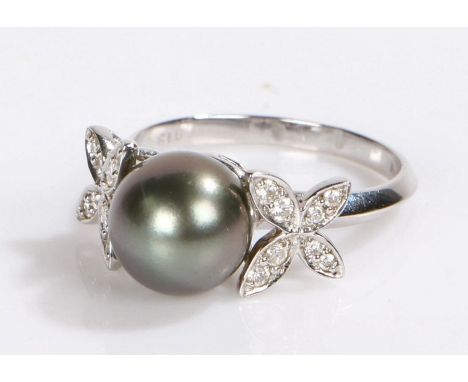 18 carat white gold pearl and diamond set ring, the central opal flanked by diamond set petals, the diamonds at a total of 0.