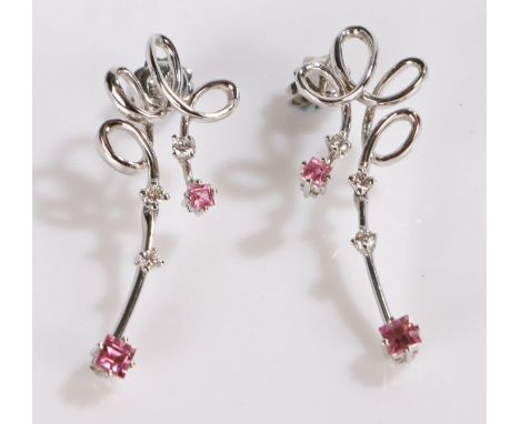 Pair of 18 carat white gold diamond and pink gemstone earrings, each with a swirl above the stone drops, 41mm long, 7.7 grams