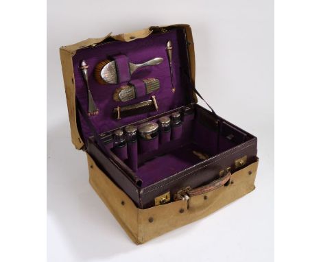 George V leather travelling vanity case, the purple leather case with embossed gilt initials M.E.M. to the lid, the purple wa