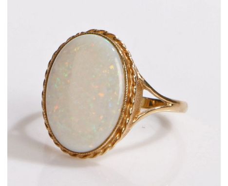 9 carat gold opal set ring, the large cabochon cut opal set to a rope twist edge, 3.6 grams, ring size S