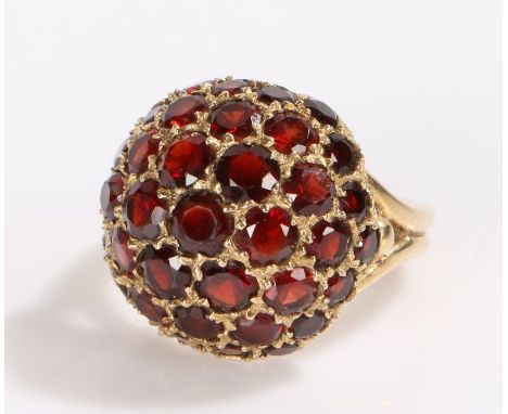 9 carat gold garnet set ring, the dome head set with a series of round cut garnets, 7.4 grams, ring size M