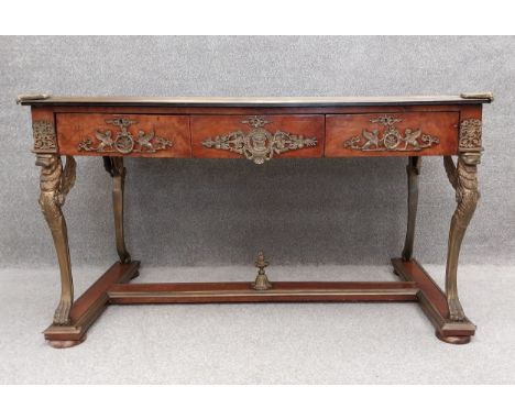 A large Empire style burr walnut and mahogany console table with a tooled leather top above three ormolu mounted frieze drawe