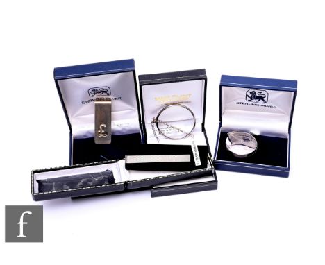 A sterling silver money clip with reticulated Pound symbol, and other sterling silver novelty items including magnifying glas