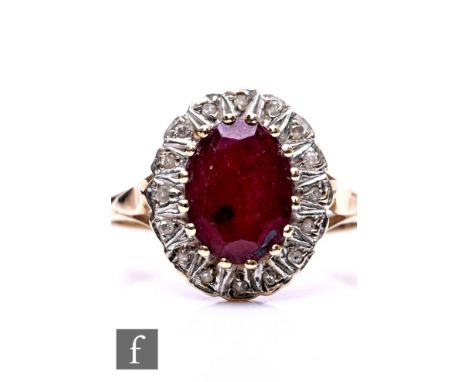 A 9ct hallmarked ruby and diamond oval cluster ring, central ruby within a diamond border, weight 2.8g, ring size L 1/2.