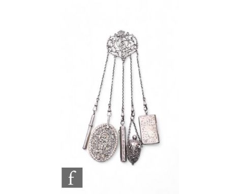 A silver chatelaine with five various items attached to include a thimble and holder, a stamp case, aide memoire slide pencil