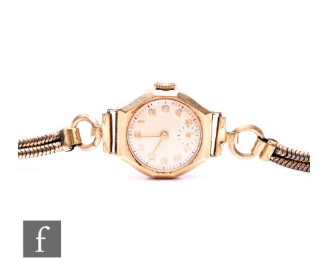 A 9ct hallmarked lady's manual wind wrist watch, Arabic numerals to a circular dial, to a rolled gold bracelet, total weight 