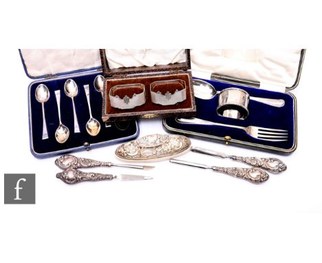 A small parcel lot of assorted silver items to include a pair of cased napkin rings, teaspoons, a christening knife, fork and