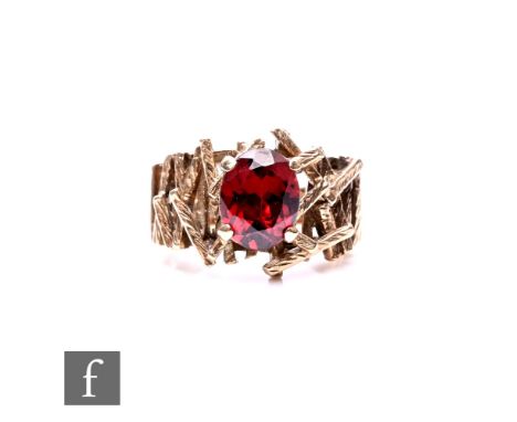 A 9ct hallmarked single stone garnet ring, oval claw set stone to a pierced bark effect stylised head, weight 5g, ring size I