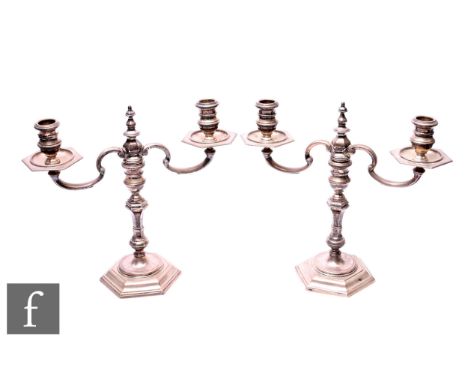 A pair of 20th Century silver twin light candelabra in the Queen Anne style, with scroll branches over hexagonal knopped stem