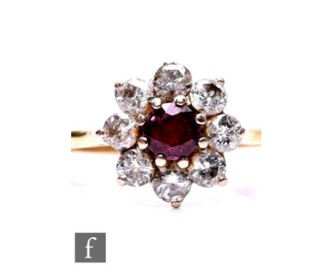 An 18ct hallmarked ruby and diamond cluster ring, central circular ruby within a border of eight 0.15ct brilliant cut diamond