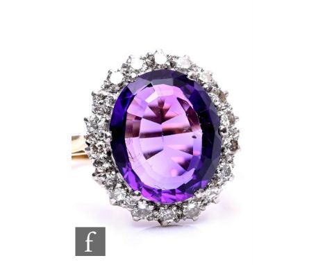 An 18ct amethyst and diamond cluster ring, central oval amethyst within a border of sixteen individually set diamonds, weight