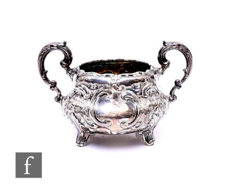 A hallmarked silver twin handled sugar basin with embossed decoration, weight 13oz, London 1867, with a pair of pierced trump