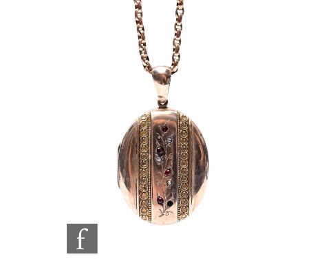 An early 20th Century 9ct oval locket set with ruby and diamonds to front suspended from a 9ct rose gold belcher chain, total