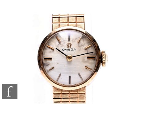 A lady's 9ct hallmarked manual wind Omega wrist watch, batons to a circular silvered dial, case diameter 16mm, to an integral