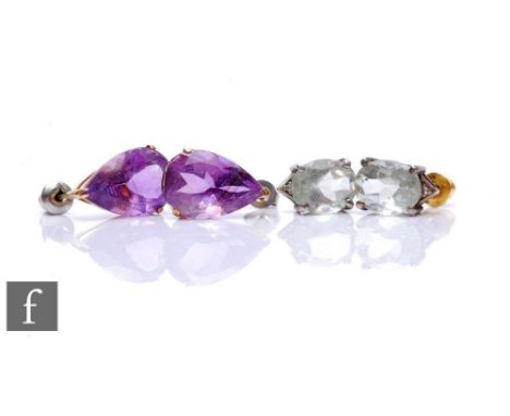 A pair of amethyst stud earrings, pear shaped claw set stones, with a similar pair of aquamarine examples.