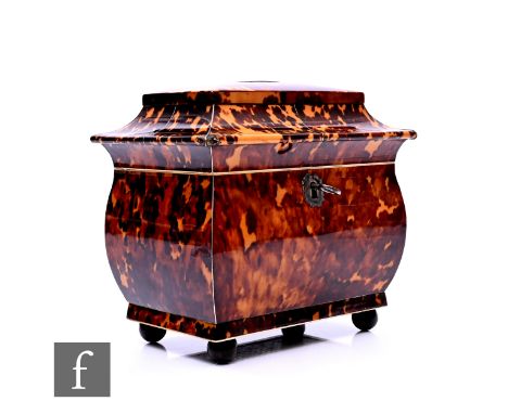 A late Regency period blonde tortoiseshell tea caddy of bombe form, with white metal stringing and ivory trim and raised to b