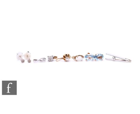 Four assorted diamond set pendants with a pair of similar earrings, an opal pendant and a pair of blue topaz stud earrings.