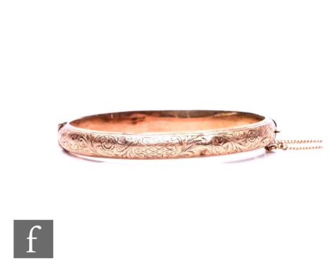 A 9ct hallmarked rose gold hinged bangle with part foliate engraved decoration, weight 8.7g, Birmingham 1906, some damage.