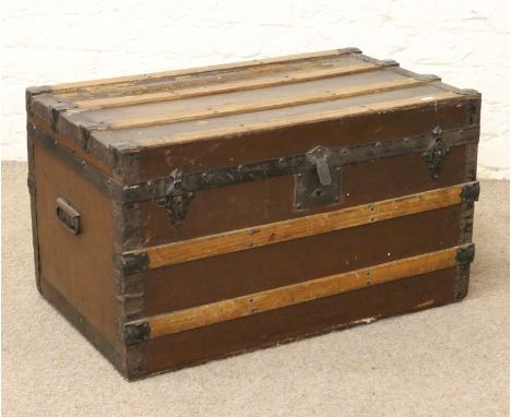 A metal and wooden bound pine travel trunk.