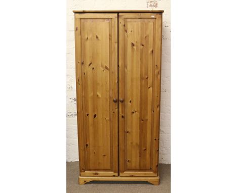 A pine two door wardrobe with integral adjustable shelf.