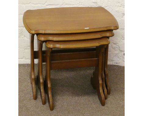 A nest of three light oak effect occasional tables.