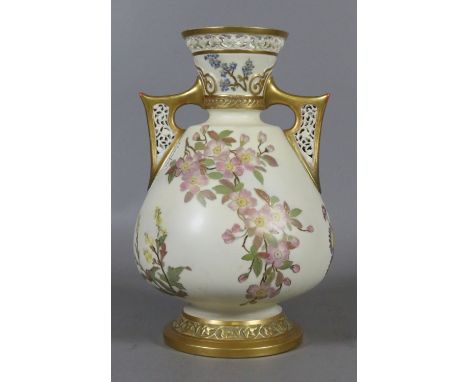 A Royal Worcester Aesthetic movement vase. Ground in old ivory, with gilded pierced twin handles and painted with flowers, (A