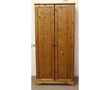 A pine two door wardrobe with integral adjustable shelf.