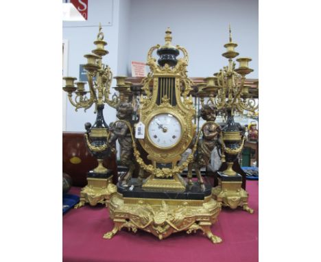 A XIX Century Style Gilded Brass Clock Garniture Set, (imperial made in Italy), clock with a final top, central enamel dial, 