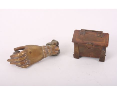 A brass door knocker modelled as a lady's hand holding a ball and an Arts & Crafts brass and copper casket