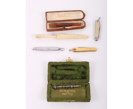 A bone umbrella needle case, an "amber" cigarette holder, a silver propelling pencil and three miniature penknives