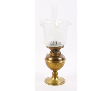 A brass oil lamp with etched shade and chimney