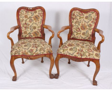 A set of four Queen Anne design figured walnut open armchairs with shaped backs and stuffed over seats upholstered in a flora