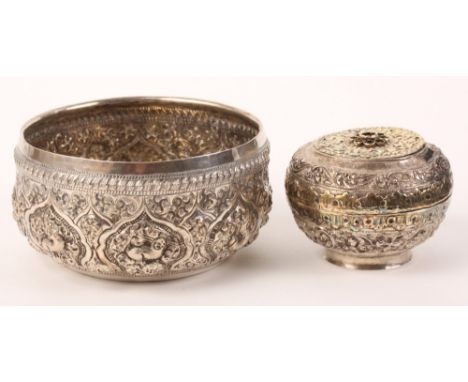 An Eastern silver circular box and cover with embossed decoration and an Indian white metal bowl with embossed decoration