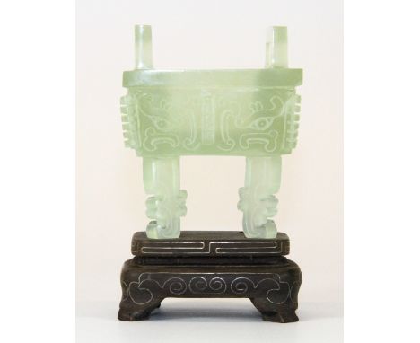 A beautiful carved archaic form jade sensor mounted on a white metal inlaid hardwood stand (H:10cm) Est. £200-300