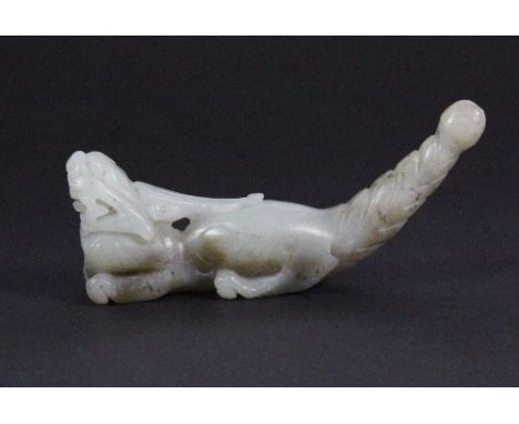 An interesting 19th/ early 20thC carved celadon jade cheroot holder in the form of a dragon with the tail as the mouthpiece (