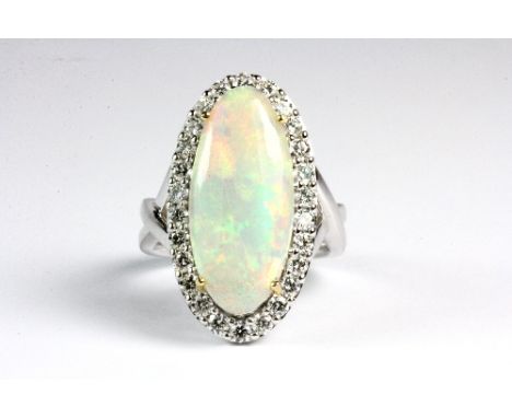  
Beautiful 18ct white gold ring set with a large opal (approx 3.65ct) surrounded by diamonds. (N). Est. £1200 - 1400