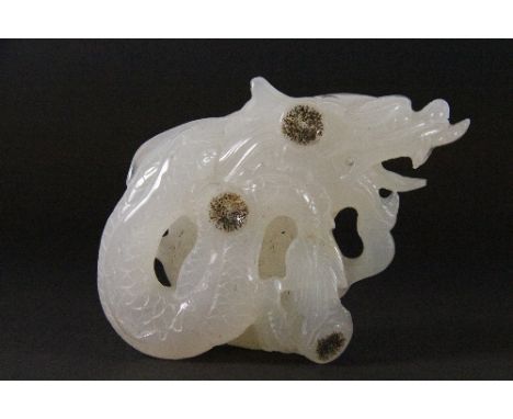 A Chinese carved white jade/hardstone figure of a dragon with enhanced natural features to the stone (13cm x 9cm x 5cm) proba